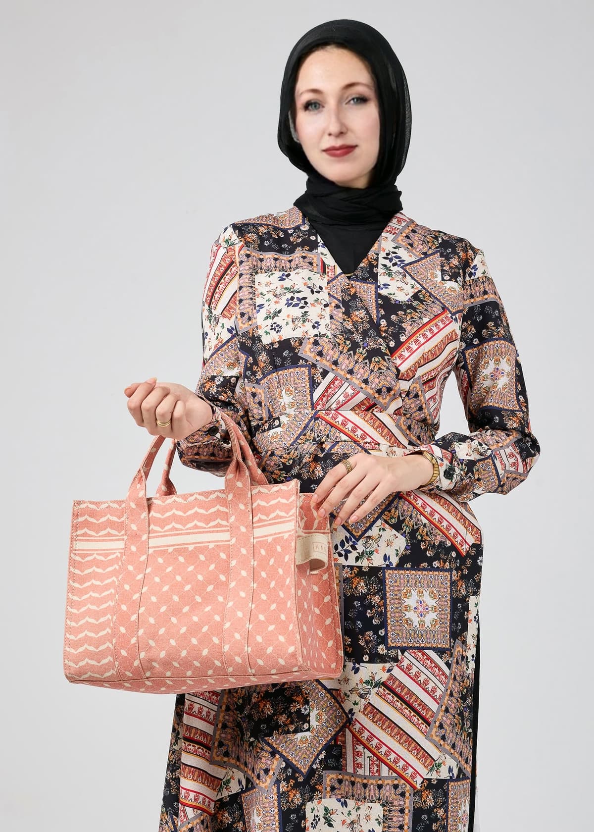 Model holding a bag while wearing the Vienna Mosaic Printed Wrap Maxi Dress