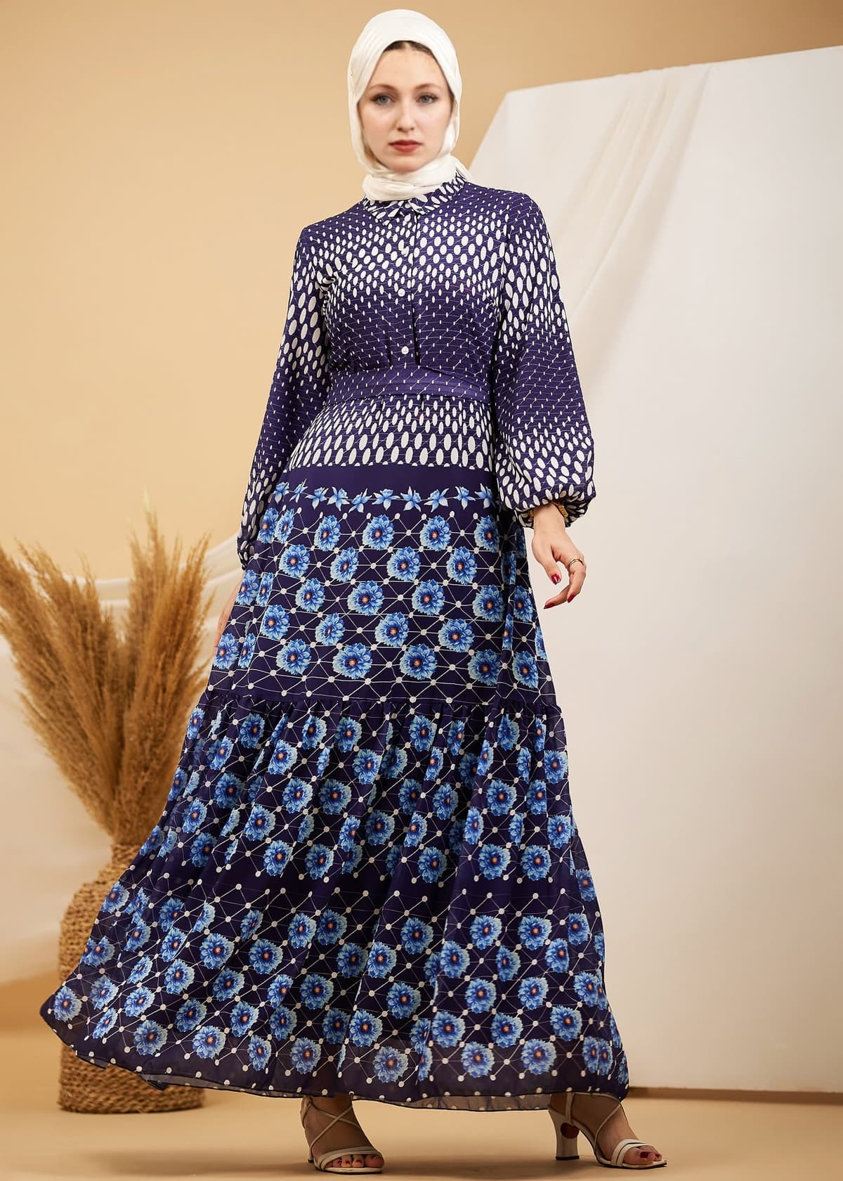 Front view of a navy floral chiffon maxi dress with high neck and flared sleeves