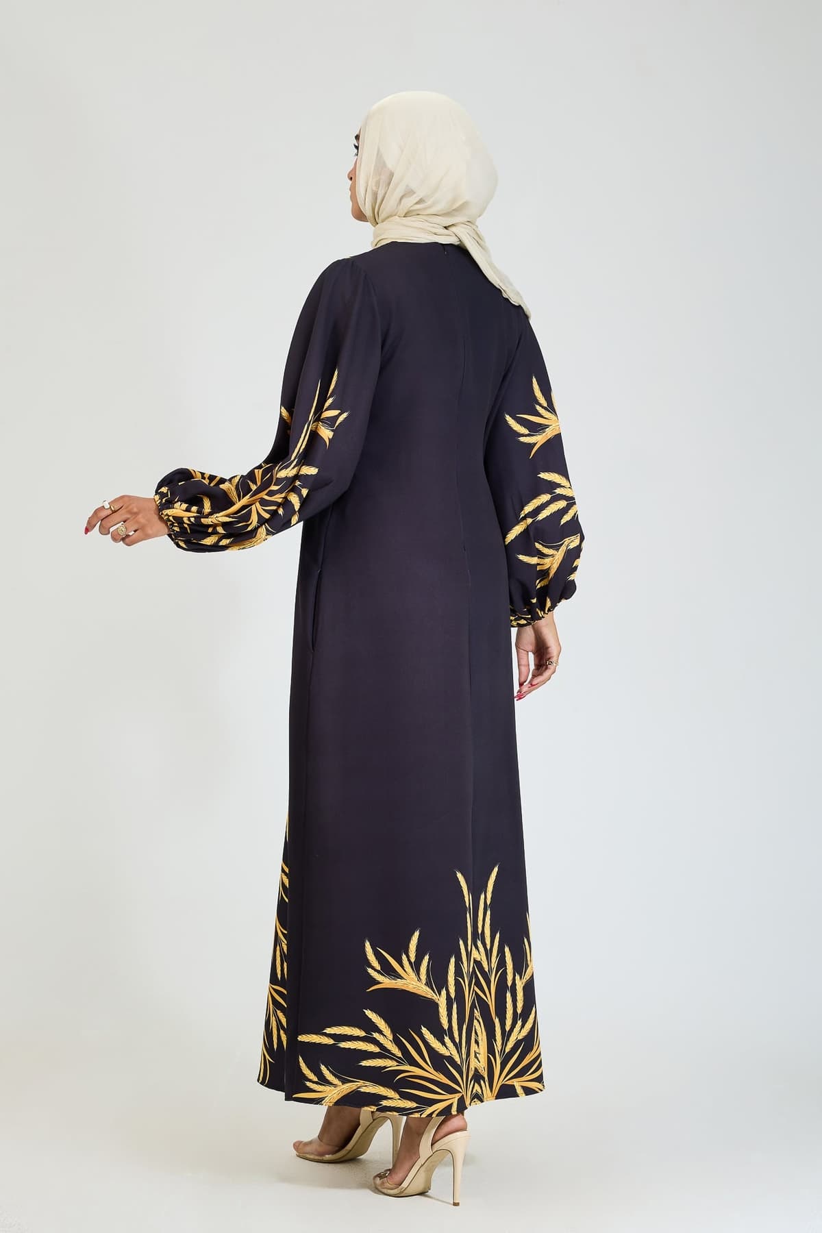 Back view of black crepe modesty dress with golden leaf pattern.