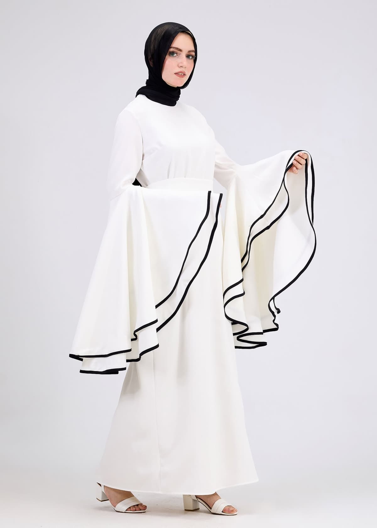 Model wearing white flared sleeve dress back view