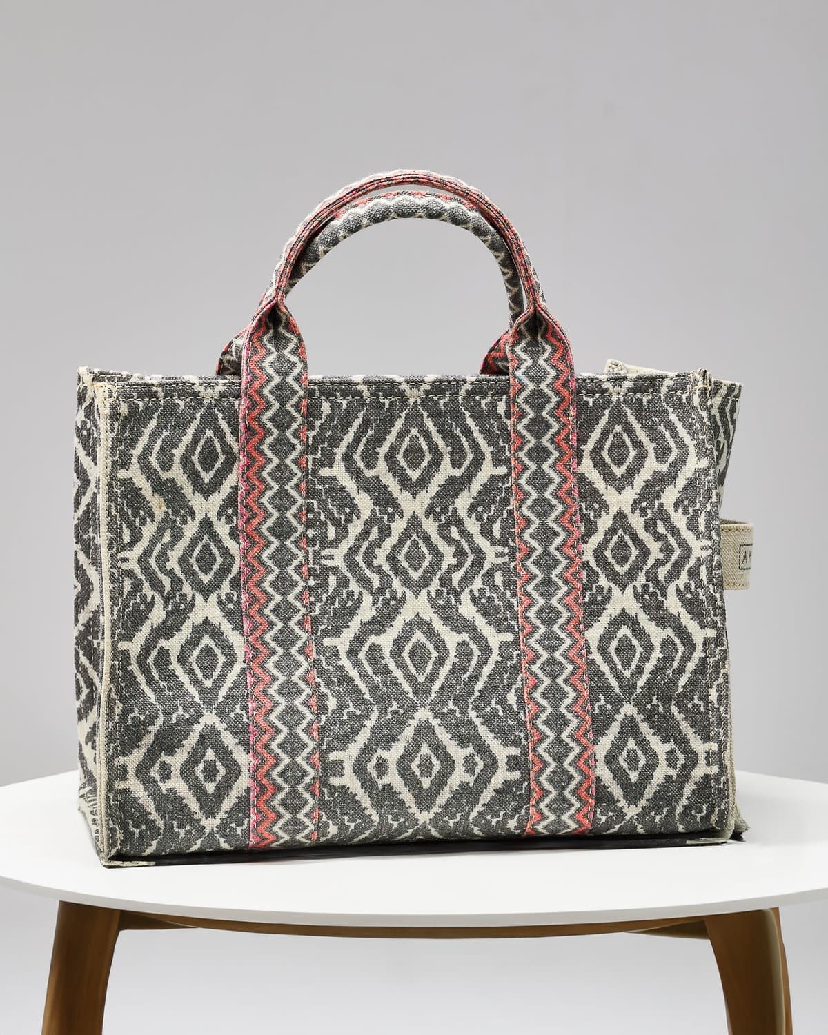 Crossbody view of gray and coral tote
