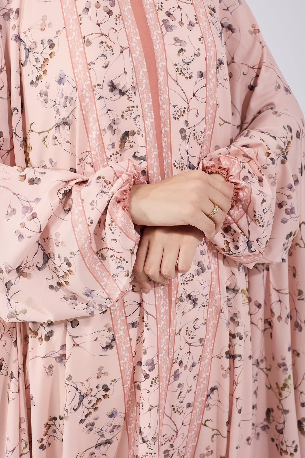 Close-up of hands in elastic cuffs of the satin floral gown