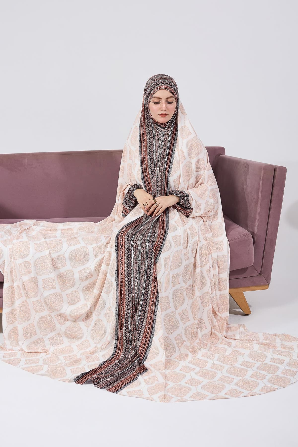 Satin gown dress in bohemian print, side profile of model sitting